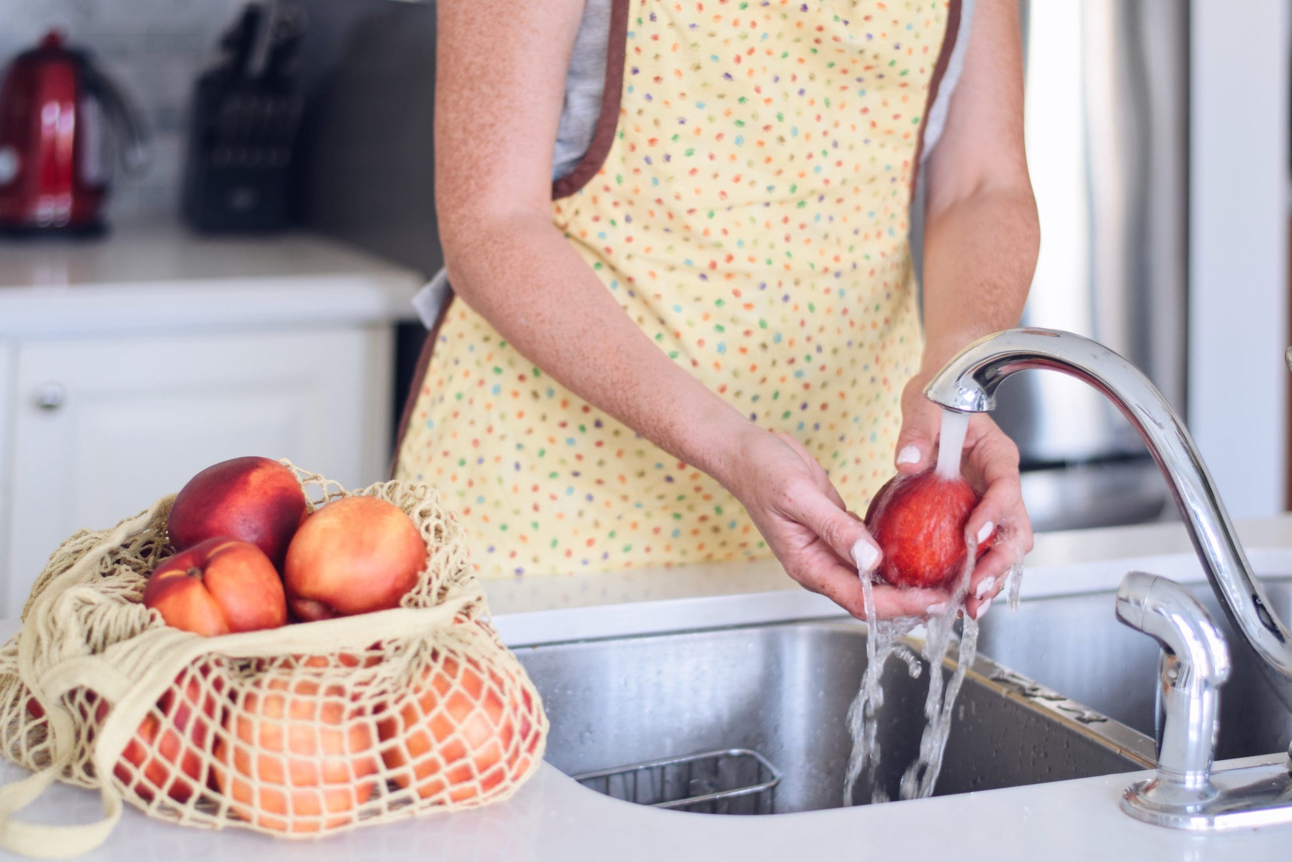 Woman washing apples in her sink