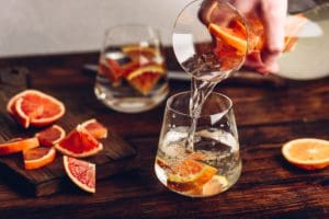 Pouring infused water with bloody oranges into the glass