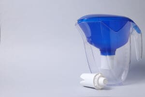 Water filtration water filter pitcher with a blue cap on a white background